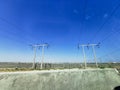 A very long and tall electric supply chain of tall metal towers on the top of dried mountains Royalty Free Stock Photo