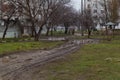 Very muddy road with puddles and swamps along the high rise building. Selective focus background