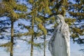 Very old and ancient stone statue of Virgin Mary against blue sky and trees Royalty Free Stock Photo