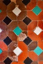 Very old Andalusian Arabic style ceramic tile pattern with geometric shapes and red, orange, green and white colors