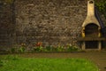 Very old brick wall with built-in grill, bright tulips on the background of old brick.