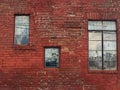 Very old brick wall in need of pointing repair with three different windows, architectural background Royalty Free Stock Photo