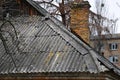 Very old damaged asbestos slate roof and chimney