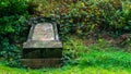 A very old gravestone fallen backwards on to a grass verge