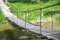 Very old hanging footbridge across river