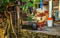 Very old hunched woman fills a jerrycan with water