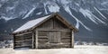 Very old log barn made of wood with snow on the roof in winter