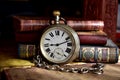 Very old pocket watch and books on a table Royalty Free Stock Photo