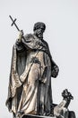 Very old roof statute of high ranked priest with a cross and a dragon in historical downtown of Dresden, Germany, details, closeup