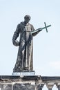 Very old roof statute of high ranked priest with a cross and human skull in historical downtown of Dresden, Germany, details,