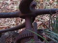 A very old rusted and worn machine wheel and cog.