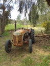 Very Old Rusty Coloured Tractor used with a saw at its rear to cut wood