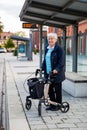 Very old senior woman waiting at the bus stop with walker Royalty Free Stock Photo