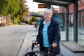 Very old senior woman waiting at the bus stop with walker Royalty Free Stock Photo