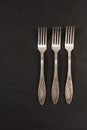 Very old set of three rusty vintage silver forks on a black cement texture background Royalty Free Stock Photo