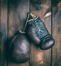 Very old shabby leather boxing gloves hanging on a nail Royalty Free Stock Photo