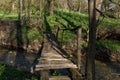 Very old small wooden bridge under small river in forest on spring day Royalty Free Stock Photo