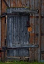 A very old and weathered gate between two yards.