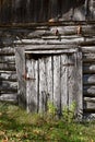 An old log cabin with a weathered rickety door Royalty Free Stock Photo