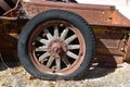 Rotten tire with wooden spokes on the wheel on a rusty box of a truck