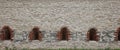 Very old window in brick stone wall of castle or fortress of 18th century. Full frame wall with window Royalty Free Stock Photo
