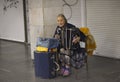 Very old woman, street musician, playing bayan and singing in the underground passage