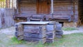 A very old wooden well in the yard of an old wooden house with a wooden bucket. Royalty Free Stock Photo