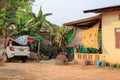 A very poor village house and an expensive car in a makeshift garage. Laotians prove their statues with an expensive car. Social g