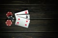 A very popular poker game in America with a winning combination of three of a kind. Cards with chips on a dark table in a poker