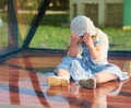 Very realistic doll resembling a crying little girl sitting behind glass