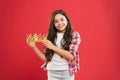 A very rich reward. Little girl holding crown reward on red background. Successfil small winner with precious reward for