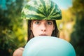 Very ridiculous girl writhes her face holding two halves of watermelon. The biggest discounts for all autumn clothes for