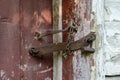 Very rusty padlock closing a wooden door, closeup. An old wooden gate locked with an equally old rusty padlock. Vintage background Royalty Free Stock Photo