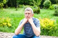 A very sad senior man is sitting in the park. Old age, loneliness, depression, problems. Close-up