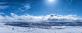 Very scenic panorama view at Scandinavian Mountains, people at ski lift. Sunny day snowing a bit, much snow and blue skies with Royalty Free Stock Photo
