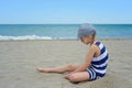 Very serious cute little girl sitting on the beach