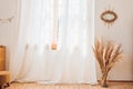 A very simple window with curtains in a rural house with a wooden floor and dry grass in a vase on a sunny day Royalty Free Stock Photo