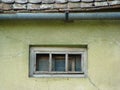 Very small window under the roof. Village house. Old.