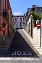 Very steep street with a stop sign at the bottom of the street and typical houses of the town of Arucas in Gran Canaria. Europe