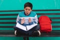 Very surprised boy reading his book sitting on a bench Royalty Free Stock Photo