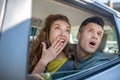 Very surprised man and woman looking out of the car. Royalty Free Stock Photo