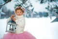 Very sweet beautiful little smiling girl child in pink skirt, white pullover, gray scarf and floral wreath with lantern in hands. Royalty Free Stock Photo