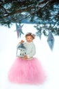 Very sweet beautiful little smiling girl child in pink skirt, white pullover, gray scarf and floral wreath with lantern in hands. Royalty Free Stock Photo