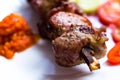 Very tasty cuts of meat are planted on a skewer and fried over an open fire. The meat lies on a white plate. Royalty Free Stock Photo