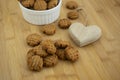 Very tasty peanut butter biscuits on bamboo wooden board in white baking bowl and decorative wood heart, golden baked healthy Royalty Free Stock Photo