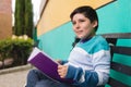 Very thoughtful boy on a park bench studying quietly