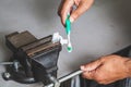 Squeezes toothpaste from tube with vise Royalty Free Stock Photo