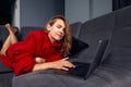 Very tired young woman, burning the midnigh oil - working late at night on her laptop computer, at home, sitting on sofa Royalty Free Stock Photo