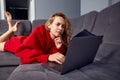 Very tired young woman, burning the midnigh oil - working late at night on her laptop computer, at home, sitting on sofa Royalty Free Stock Photo