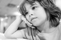 Very unhappy sad kid looks away. Boy waiting for someone in the cafe. Royalty Free Stock Photo